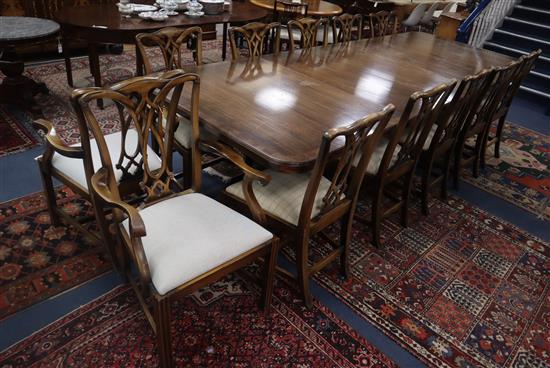 A reproduction mahogany twin pillar extending dining table together with twelve Georgian style dining chairs (two with arms) Table 320c